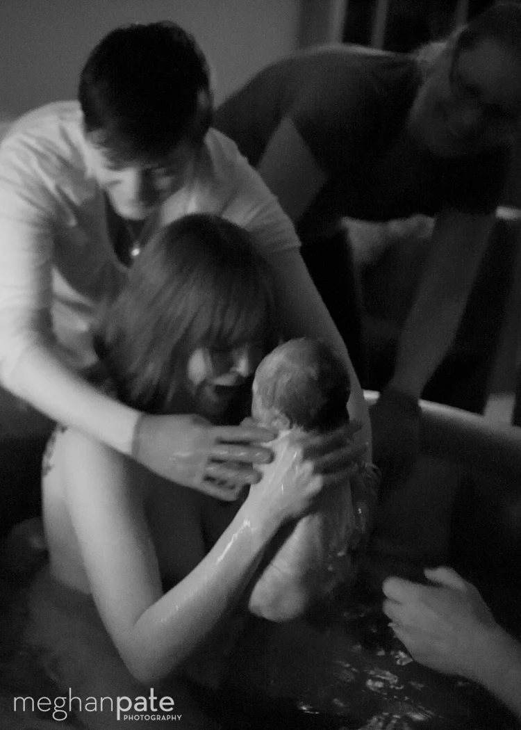 The Safety of Waterbirth A TCM mama meeting her baby in the tub